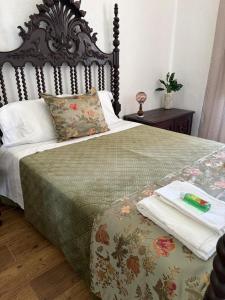 a bedroom with a bed with a wooden headboard at Casa dos Tios- Estremoz in Estremoz