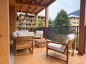 a screened porch with two chairs and a table at Alpine Dream Apartments in Bormio