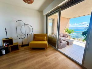 a living room with a yellow chair and a sliding glass door at Casamea - Terrasse Mer, Plage 5min, Barbicaja in Ajaccio