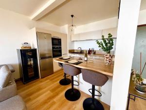 a kitchen with a counter with two bar stools at Casamea - Terrasse Mer, Plage 5min, Barbicaja in Ajaccio +11 photos
