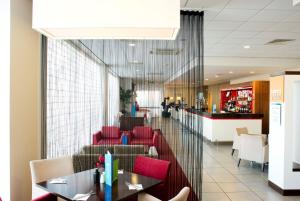 a dining room with red chairs and a table at Holiday Inn Express Rotherham - North by IHG in Rotherham