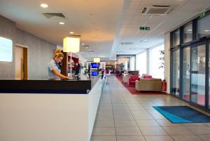 a woman standing at a counter in a lobby at Holiday Inn Express Rotherham - North by IHG in Rotherham