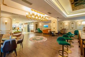 eine Lobby mit grünen Stühlen und Tischen in einem Gebäude in der Unterkunft Marble Hotel in Istanbul