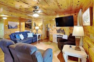 a living room with couches and a flat screen tv at Bluff Mountain Vista in Sevierville