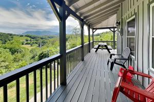 a porch with two benches and a view of the mountains at Bluff Mountain Vista in Sevierville +53 photos