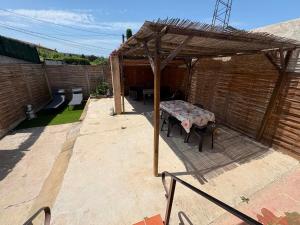 a patio with a table and a wooden canopy at Mareva House - Discreet with parking in Gignac-la-Nerthe +2 photos
