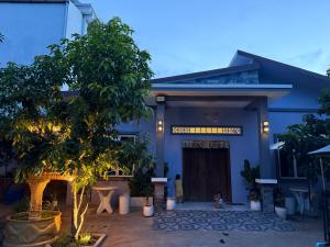a blue house with a tree in front of it at Bun Homestay in Battambang