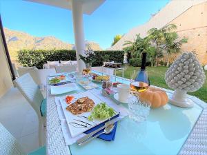 a table with plates of food and wine on it at Villa Mastrissa Taormina - Private Villa with 2 pool in Taormina
