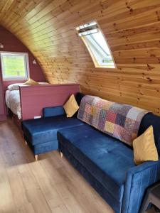 a room with a couch and a bed in a cabin at Leahys Pod Park in Cork