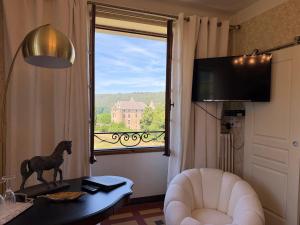 a living room with a window with a horse on a table at Hôtel du Moulin in Allemagne-en-Provence