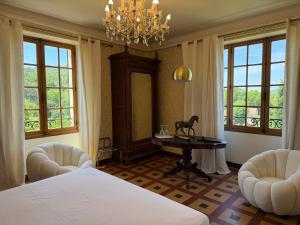 a bedroom with a bed and a table and chairs at Hôtel du Moulin in Allemagne-en-Provence