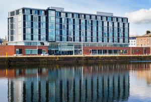 a large building next to a body of water at Apex City Quay Hotel & Spa in Dundee