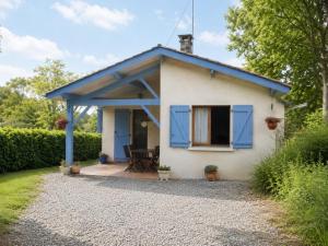 a small white house with blue shutters and a patio at Tastet in MouscardÃ¨s