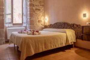 a bedroom with a bed with two baskets on it at S'Asilo Boutique B&B - North Sardinia - Village stay in Banari