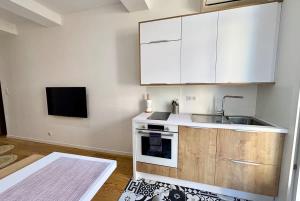 a kitchen with white cabinets and a sink at Casamea - Studio, Terrasse, Clim, Centre hist in Ajaccio