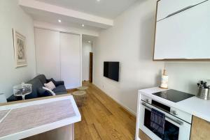 a kitchen and living room with a couch and a stove at Casamea - Studio, Terrasse, Clim, Centre hist in Ajaccio