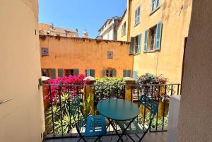 a balcony with a table and chairs and flowers at Casamea - Studio, Terrasse, Clim, Centre hist in Ajaccio +3 photos