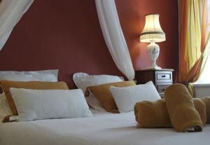 a bedroom with a bed with white pillows and a lamp at Les florentines in Carcassonne