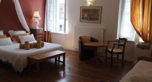a bedroom with a bed and a table and chairs at Les florentines in Carcassonne +7 photos