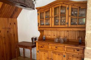 a kitchen with wooden cabinets and a wooden table at Rural French Gite Sleeps 8 with Pool and Parking in La Croix-Comtesse