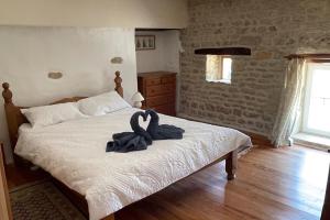 a bedroom with a bed with a swan towel on it at Rural French Gite Sleeps 8 with Pool and Parking in La Croix-Comtesse +18 photos