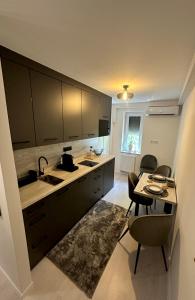 a kitchen with a sink and a table with chairs at PT Residence in Zalaegerszeg +4 photos