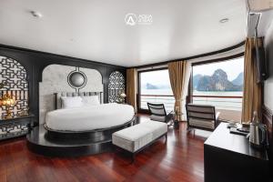 a bedroom with a bed and a table and chairs at Aqua of the Seas Cruise in Ha Long