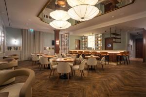 a restaurant with tables and chairs and chandeliers at The Book Hotel in Horta