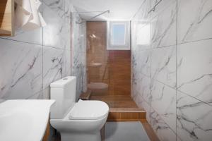 a bathroom with a white toilet and marble walls at ChaKo Stay Solutions Studio in Lamía