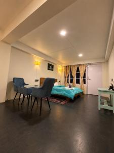 a bedroom with a bed and a table and chairs at Lungta Homes in Bomdila