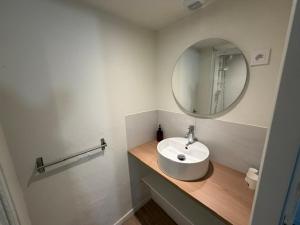 a white bathroom with a sink and a mirror at Couett' Hotel Rumilly in Rumilly