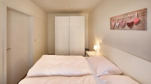 a bedroom with a bed and a painting of hearts at Düne, App 9 in Duhnen