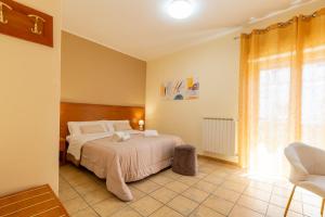 a bedroom with a bed and a large window at La Zagara Rooms - Porto di Milazzo in Milazzo