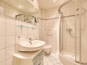 a bathroom with a sink and a shower and a toilet at Haus Schildt, FeWo 6 in Duhnen