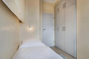 a small bedroom with a bed and a closet at Haus Schildt, FeWo 6 in Duhnen +1 photo