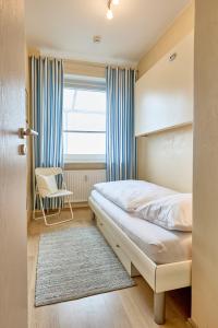 a bedroom with a bed and a window at Haus Schildt, FeWo 6 in Duhnen