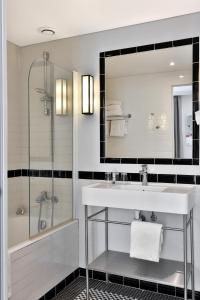 a bathroom with a sink and a shower and a mirror at Hôtel Londres et New York - Teritoria in Paris +57 photos