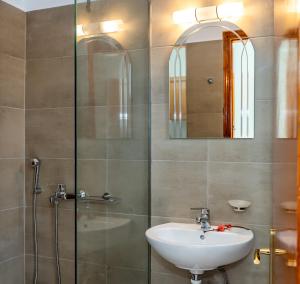 a bathroom with a sink and a glass shower at Kalofonos Studios in Laganas