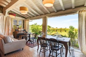 a living room with a table and chairs and a large window at Podere il Cavallo Blu in Le Focette