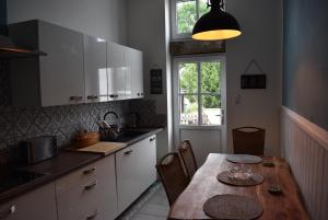 eine Küche mit einem Holztisch, Stühlen und einem Fenster in der Unterkunft Sternstunden in Breetz