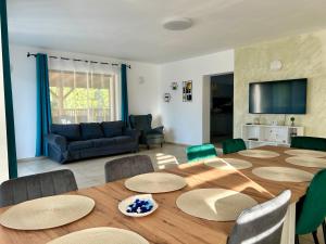 a living room with a large wooden table and chairs at Vila Safir MM in Şurdeşti