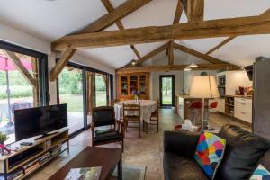ein Wohnzimmer mit Sofa und ein Esszimmer in der Unterkunft Gîte du caché in Labrit