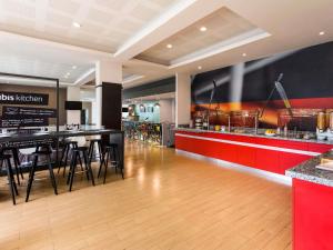 a restaurant with a bar and a counter with stools at Ibis Monterrey Valle in Monterrey