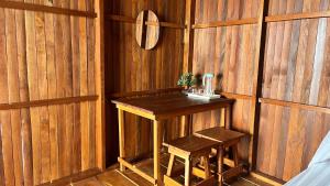 a wooden room with a table and a stool at Nyanse Homestay - Raja Ampat in Besir