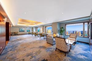 a large room with tables and chairs and windows at Shangri-La Dalian in Dalian