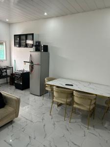 a living room with a table and a refrigerator at T1 centro da cidade cif in Luanda