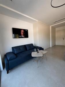a living room with a blue couch and a table at Lux Studio Lustica Bay and Car in Luštica