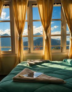 a bedroom with two beds in front of a window at Lungta Homes in Bomdila +18 photos