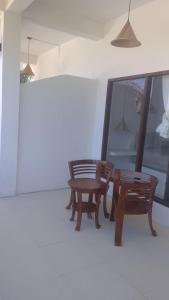 a room with a table and a bench and a mirror at NURBATA HOLDING'S Hostel in Kuta Lombok