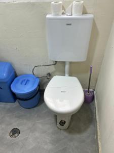 a bathroom with a toilet and two trash cans at T1 centro da cidade cif in Luanda